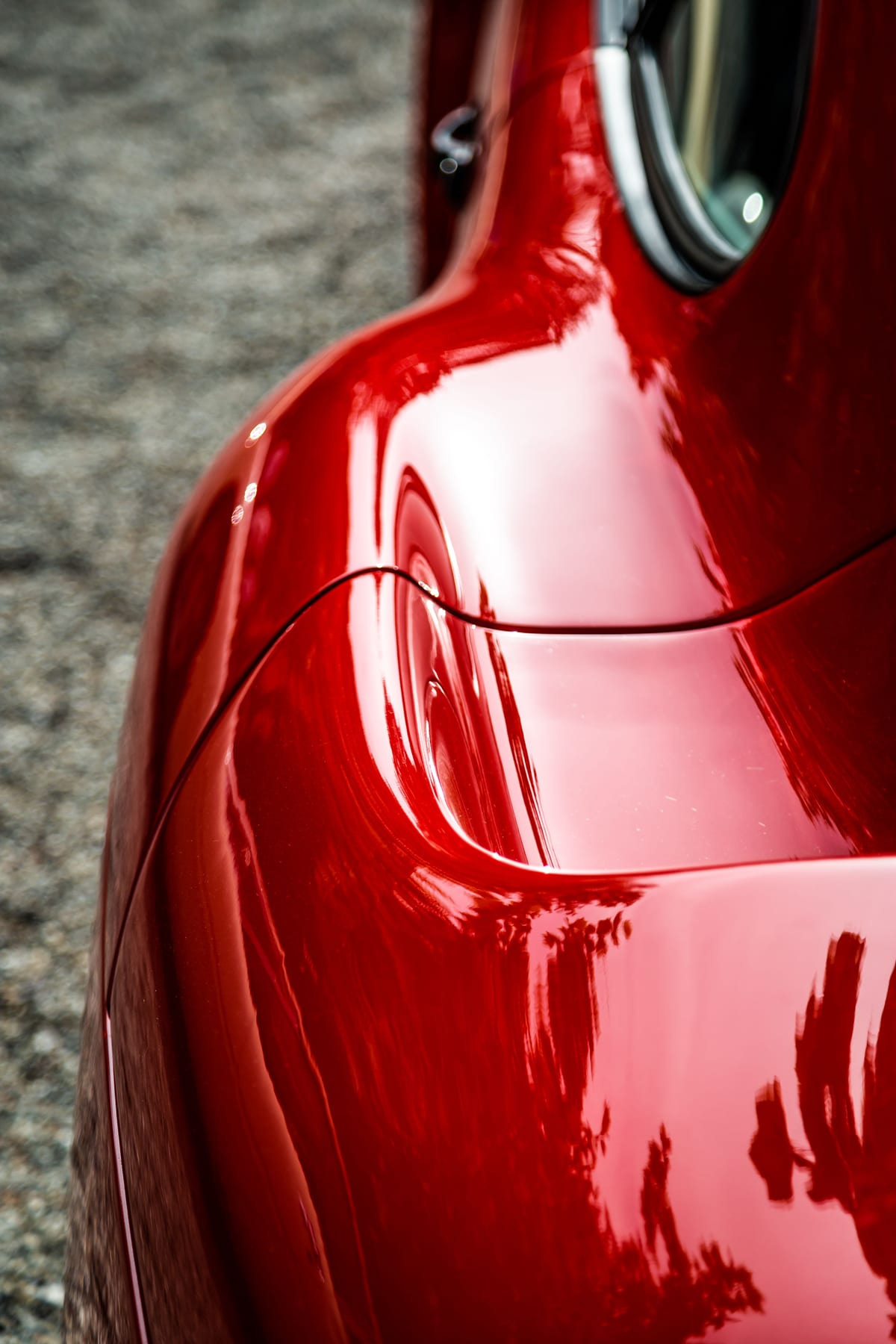Macro of deep red ceramic-coated paint, reflections holding sharp across the panel